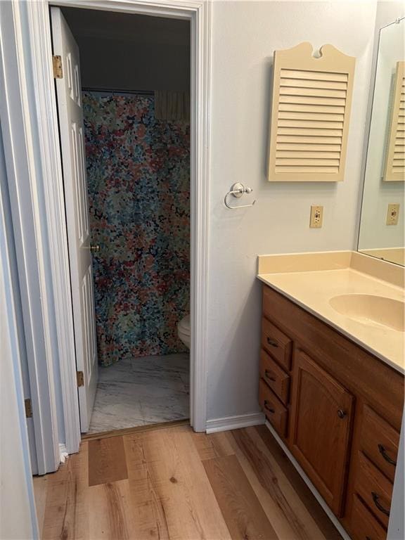 bathroom featuring vanity, hardwood / wood-style floors, and toilet