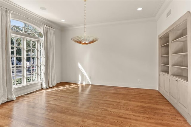 unfurnished dining area with crown molding and hardwood / wood-style flooring