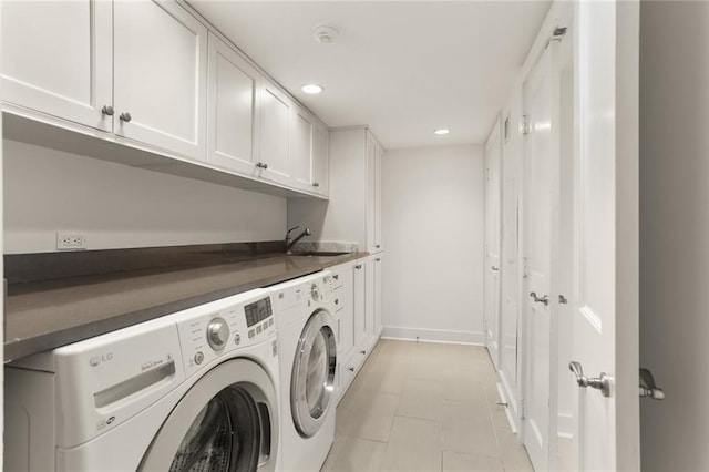 clothes washing area with cabinets, sink, and washer and clothes dryer