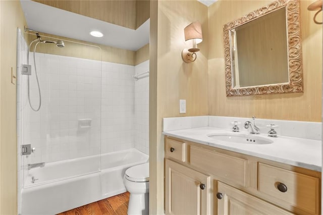 full bathroom with hardwood / wood-style flooring, vanity, toilet, and tiled shower / bath combo