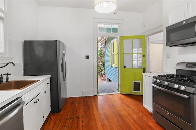 kitchen featuring dark wood-type flooring, stainless steel appliances, and white cabinets