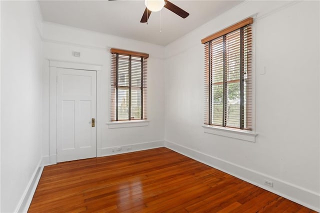 empty room featuring wood-type flooring, crown molding, and ceiling fan