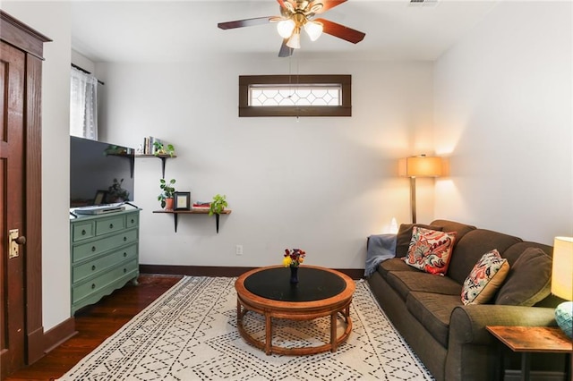 living room featuring dark wood-type flooring and ceiling fan