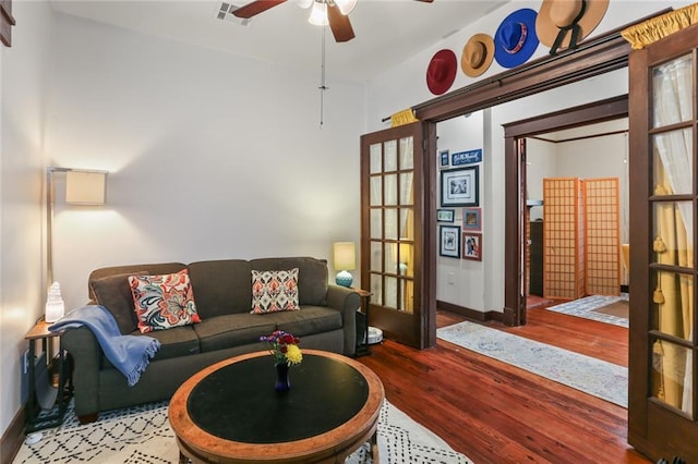 living room featuring wood-type flooring, ceiling fan, and french doors