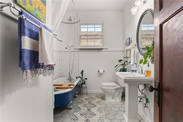 bathroom with sink, toilet, and tile patterned flooring