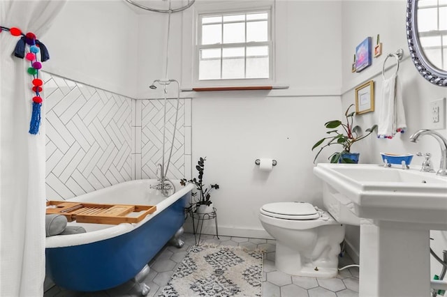 bathroom with tile patterned floors, a bathtub, and toilet