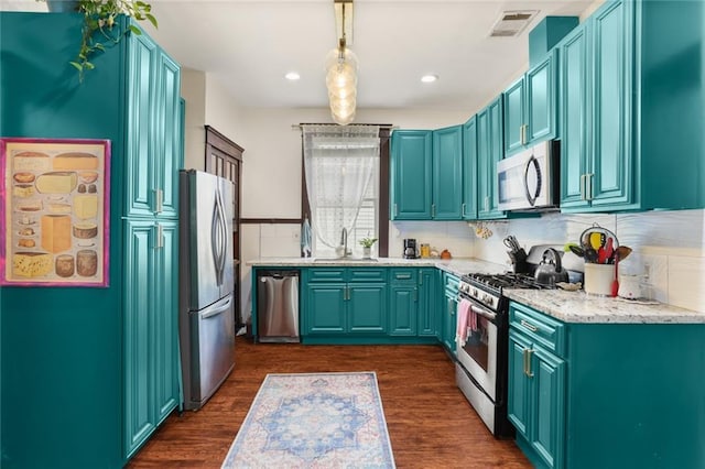 kitchen featuring pendant lighting, sink, dark wood-type flooring, and stainless steel appliances