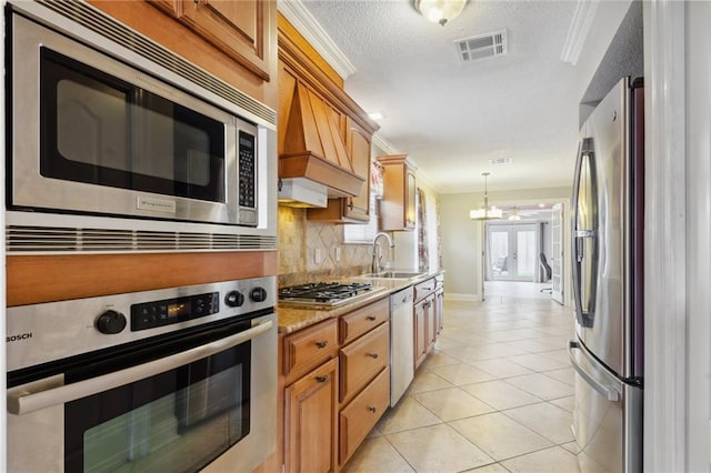 kitchen with sink, light tile patterned floors, backsplash, stainless steel appliances, and ornamental molding