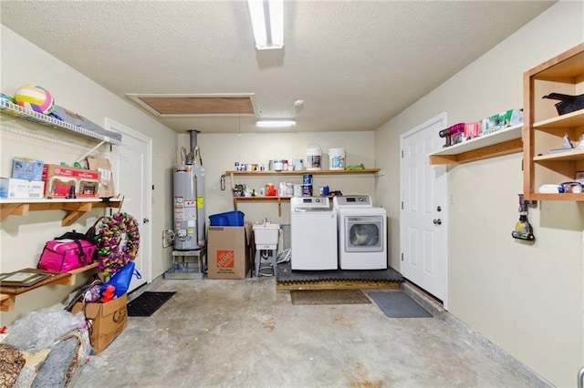 clothes washing area featuring separate washer and dryer, sink, gas water heater, and a textured ceiling