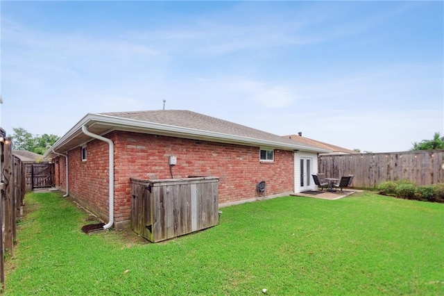 back of property with a yard and a patio area