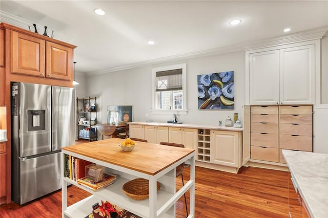 kitchen with stainless steel fridge with ice dispenser, crown molding, and light hardwood / wood-style flooring