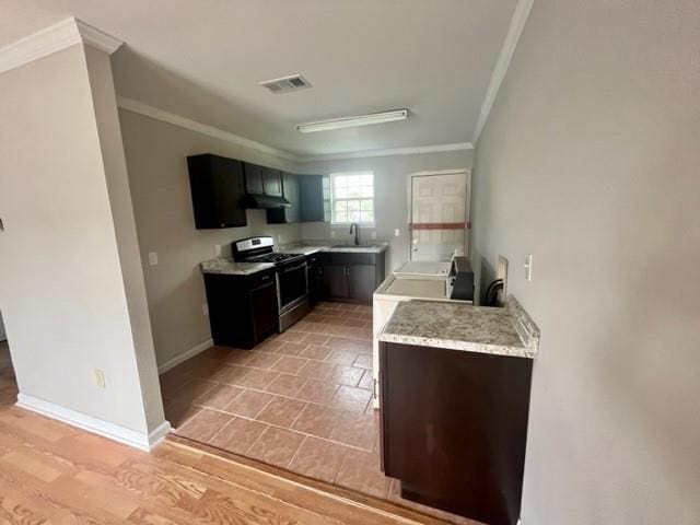 kitchen featuring visible vents, ornamental molding, stainless steel gas stove, under cabinet range hood, and baseboards