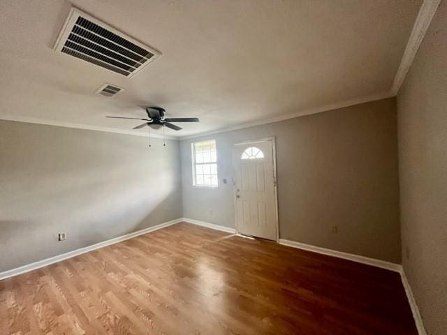 entryway with baseboards, visible vents, wood finished floors, and ornamental molding