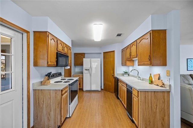 kitchen with sink, light hardwood / wood-style flooring, and black appliances