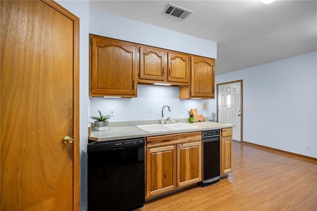 kitchen with dishwasher, sink, and light wood-type flooring