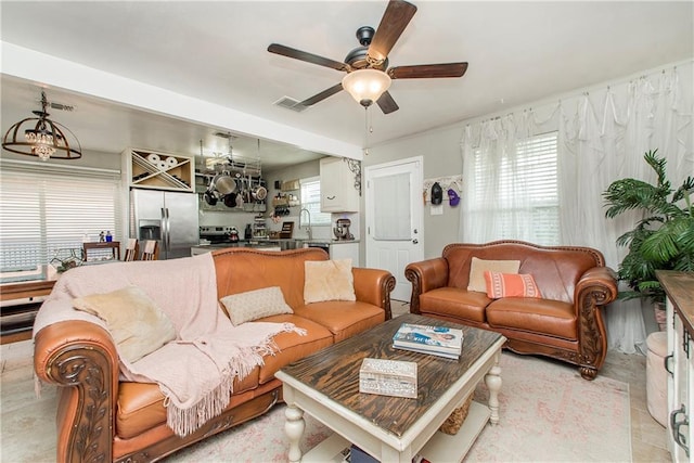 living room featuring ceiling fan, a healthy amount of sunlight, and sink