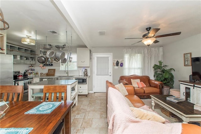 living room with sink, a wealth of natural light, and ceiling fan