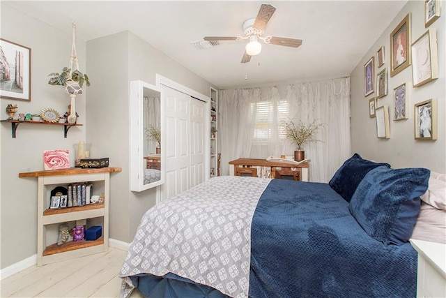 bedroom with ceiling fan, a closet, and light hardwood / wood-style flooring