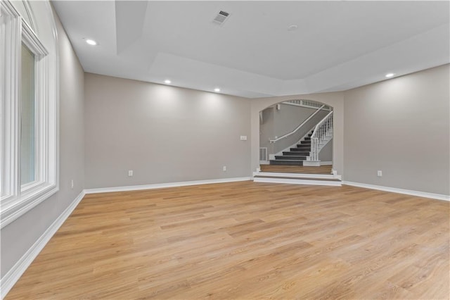 interior space with arched walkways, light wood finished floors, recessed lighting, visible vents, and baseboards