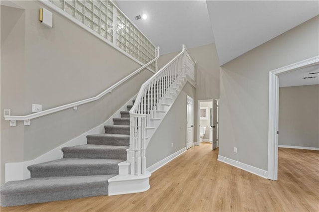 stairs with baseboards and wood finished floors