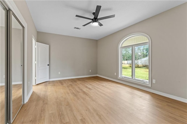 unfurnished bedroom featuring ceiling fan, visible vents, baseboards, a closet, and light wood-type flooring