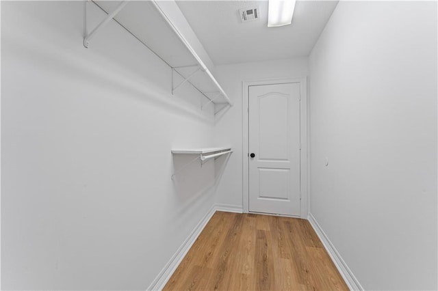 walk in closet featuring light wood-type flooring and visible vents