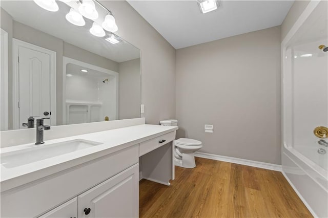 full bath featuring baseboards, toilet, wood finished floors, vanity, and a notable chandelier