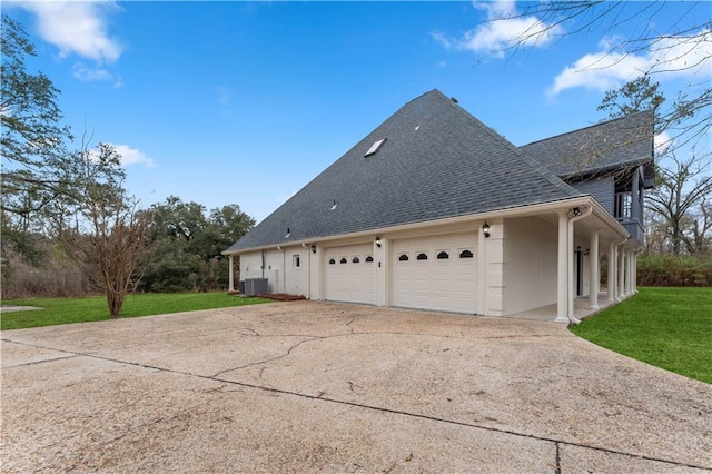 view of property exterior featuring a shingled roof, concrete driveway, a lawn, central AC unit, and a garage