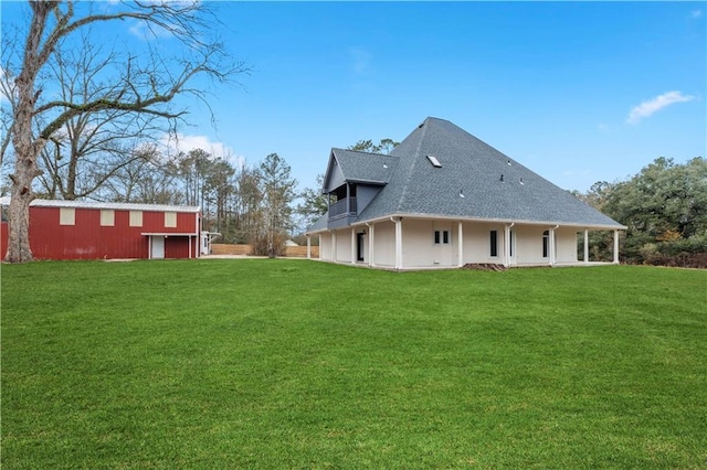 exterior space with a shingled roof, a pole building, a lawn, and an outbuilding