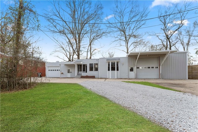 view of front of home with an attached garage, a front lawn, and gravel driveway