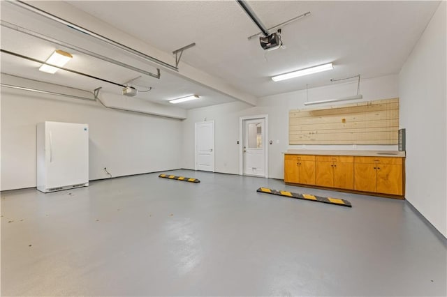 garage with freestanding refrigerator and a garage door opener