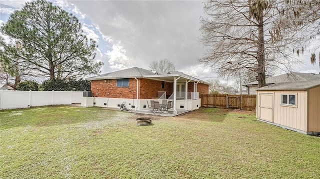 back of property featuring a patio area, a lawn, cooling unit, a storage unit, and a fire pit