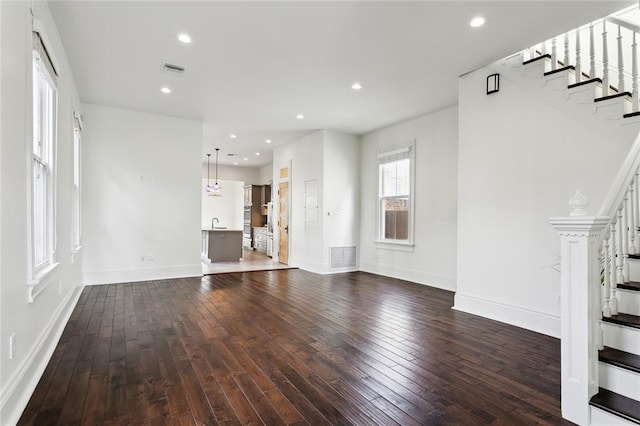 unfurnished living room featuring sink and dark hardwood / wood-style floors