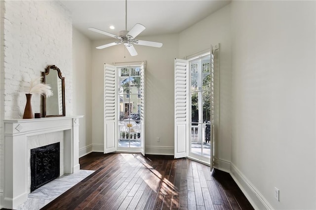 interior space featuring ceiling fan, a high end fireplace, and dark hardwood / wood-style floors