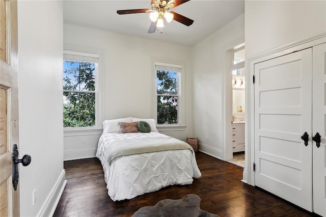 bedroom featuring ceiling fan, ensuite bath, and dark hardwood / wood-style flooring