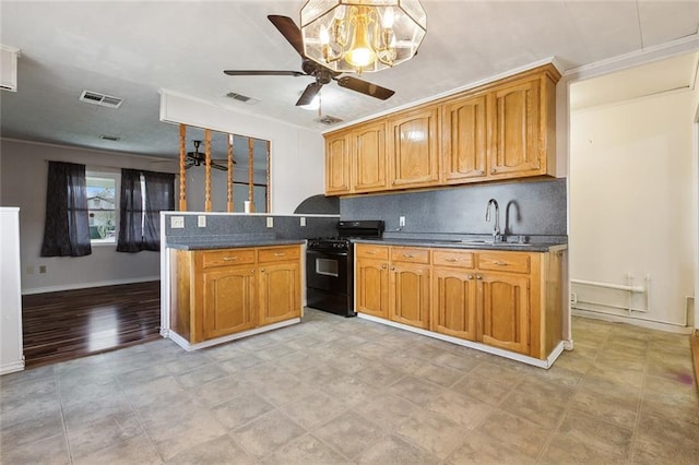 kitchen featuring dark countertops, black range with gas cooktop, brown cabinets, and a sink