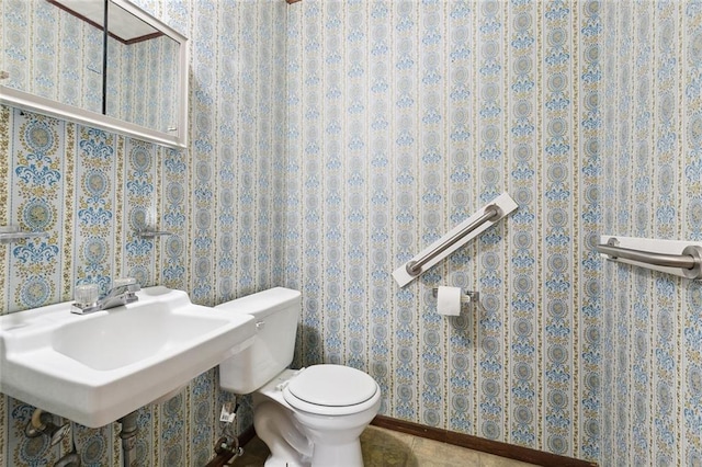 bathroom featuring tile patterned flooring, a sink, toilet, and wallpapered walls