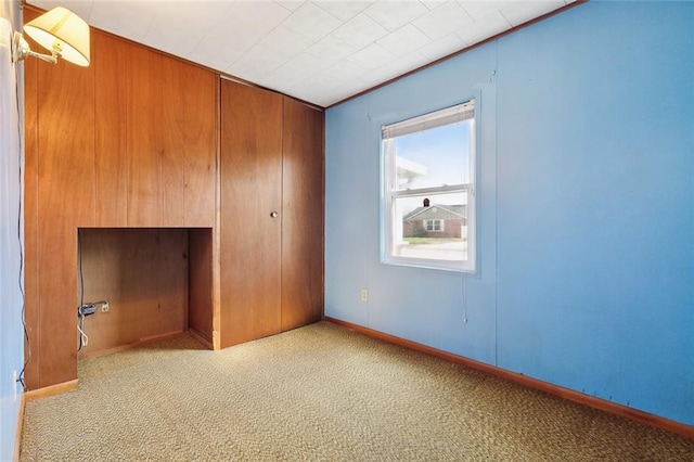 unfurnished bedroom with baseboards, a closet, and light colored carpet