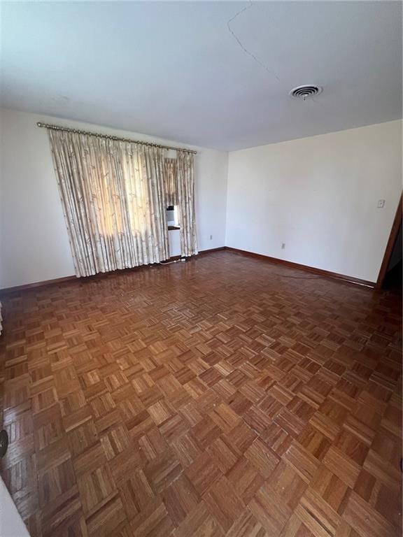 spare room with dark parquet floors