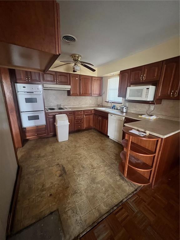 kitchen with ceiling fan, white appliances, sink, and decorative backsplash