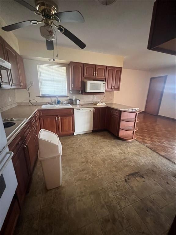 kitchen with ceiling fan, white appliances, kitchen peninsula, and sink