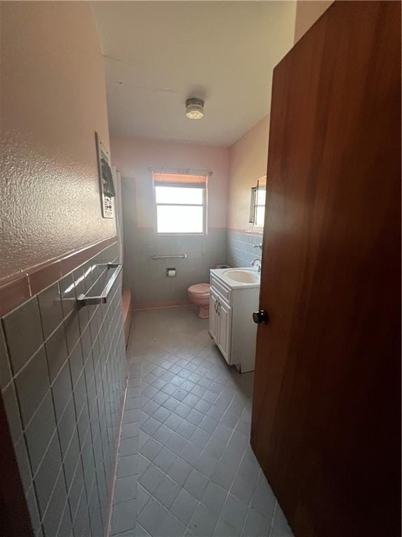 bathroom with vanity, tile patterned flooring, toilet, and tile walls