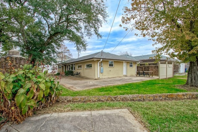 back of house with a yard and a patio