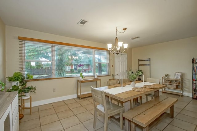 tiled dining space featuring a notable chandelier