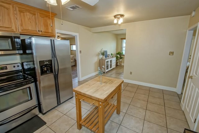 kitchen with ceiling fan, appliances with stainless steel finishes, and light tile patterned floors