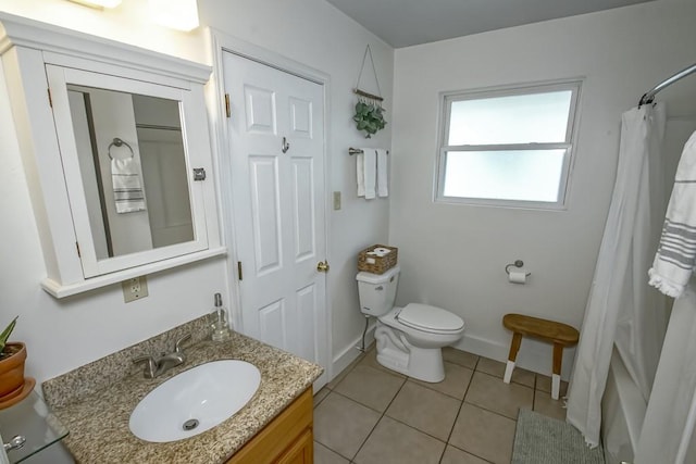 bathroom with tile patterned flooring, vanity, toilet, and walk in shower