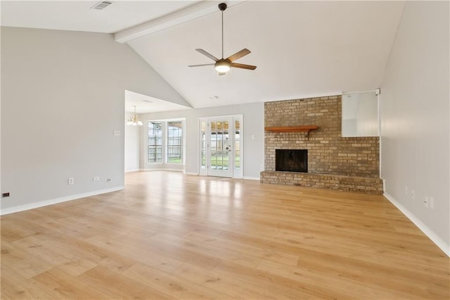 unfurnished living room featuring ceiling fan with notable chandelier, high vaulted ceiling, a fireplace, light wood-type flooring, and beam ceiling