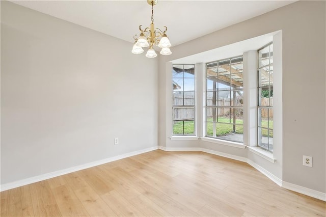 unfurnished dining area with a chandelier and light hardwood / wood-style flooring