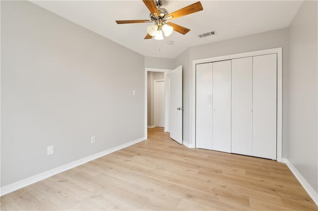 unfurnished bedroom featuring ceiling fan, light wood-type flooring, and a closet