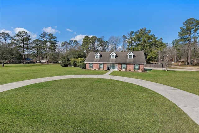 cape cod-style house with a front yard